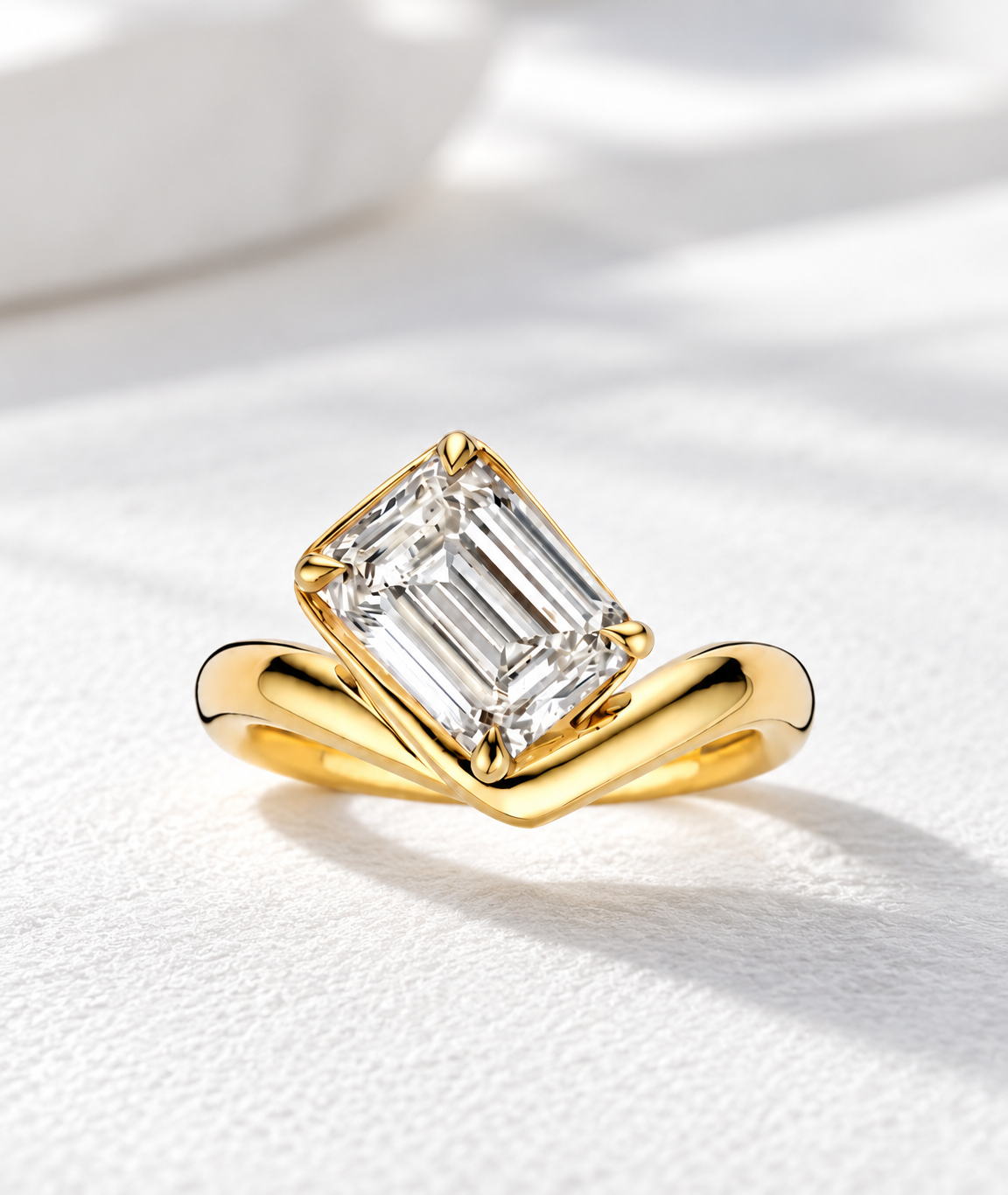 The Élan, 2ct emerald cut lab grown diamond engagement ring set diagonally on a V-shaped band in 9k yellow gold
