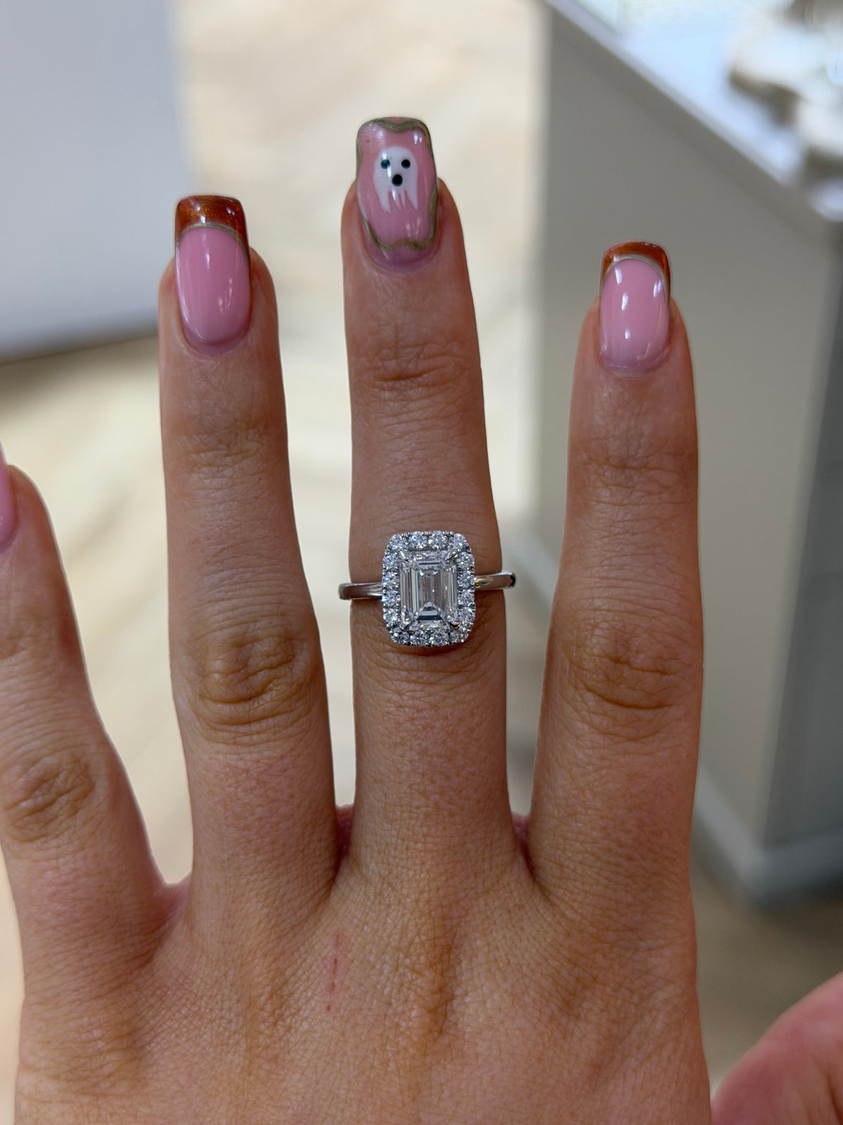 The Opulence emerald cut lab diamond halo ring, worn on the hand