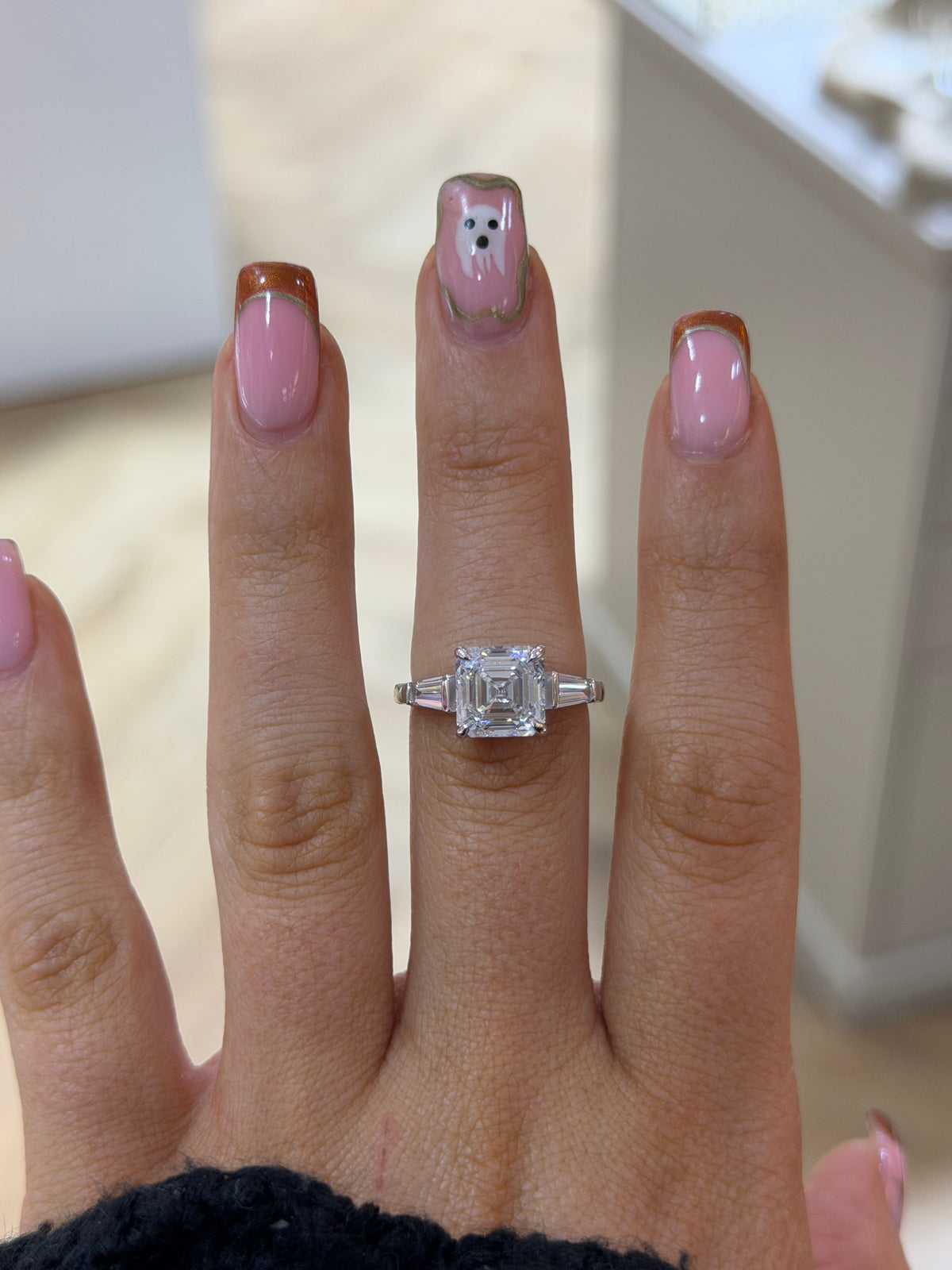 The Vivienne Asscher cut lab diamond ring with tapered baguette side stones, worn on the hand