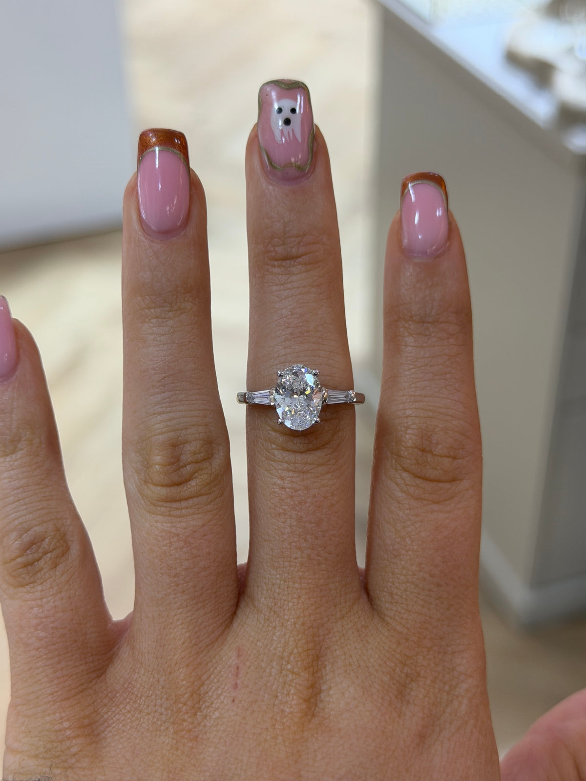 The Florence oval lab diamond ring with tapered baguette side stones, worn on the hand