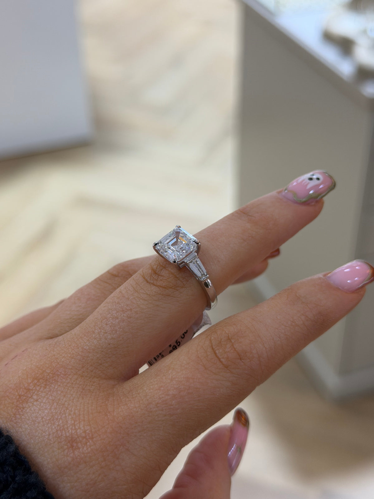 The Vivienne Asscher lab diamond three stone ring in platinum, side view on the hand