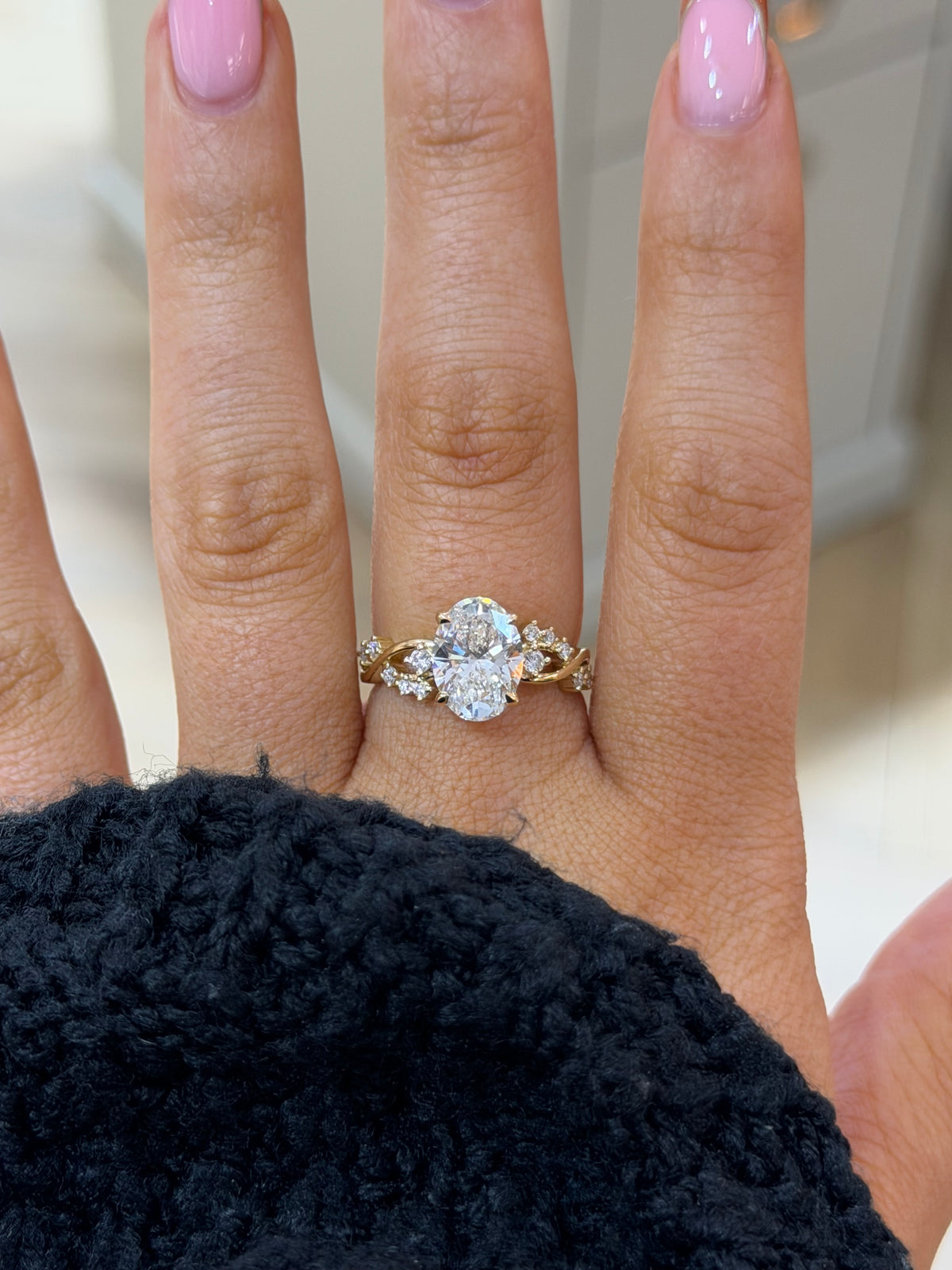 The Entwine oval lab diamond engagement ring with marquise accents, worn on the hand