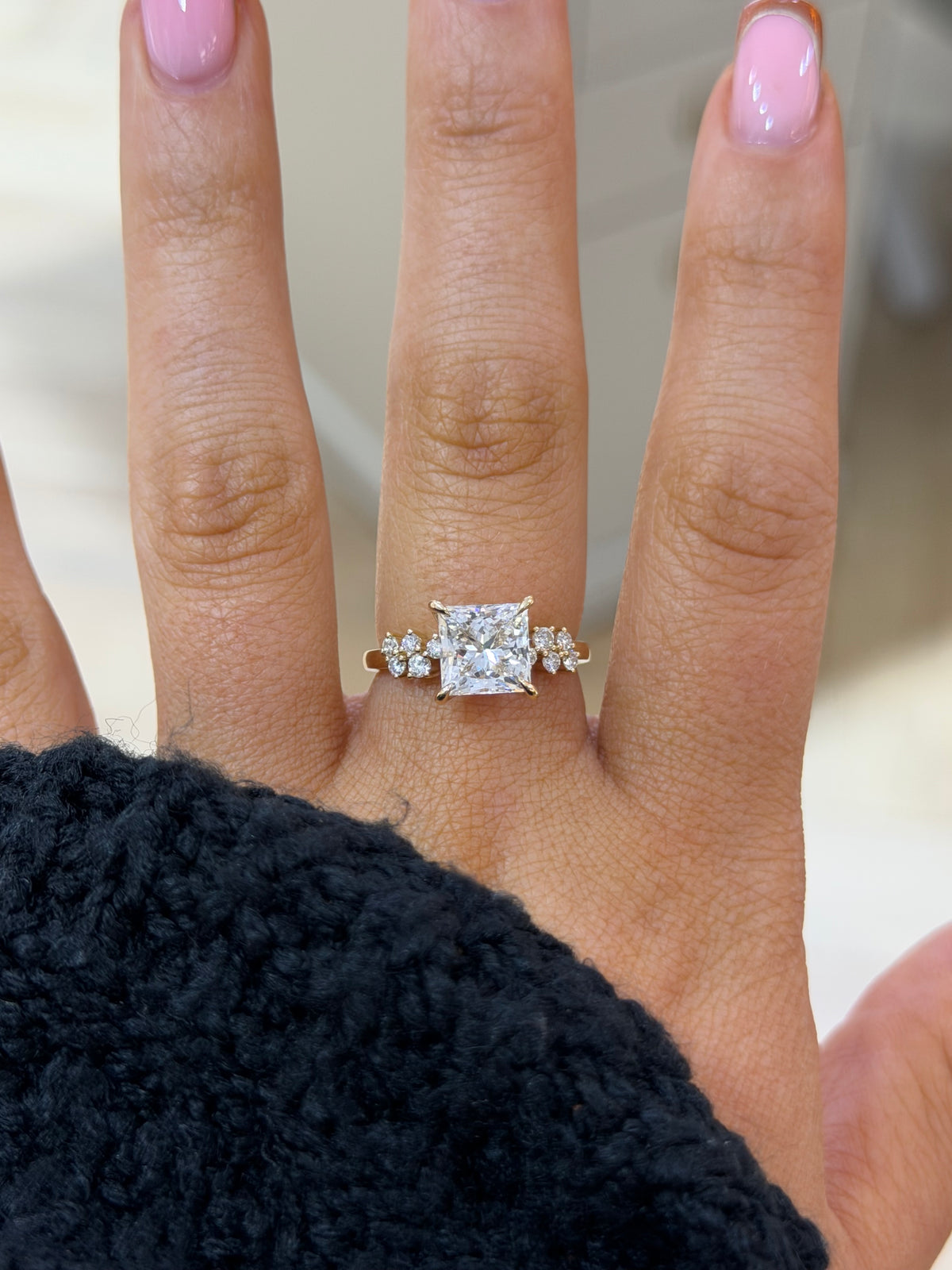 The Elara princess cut lab diamond engagement ring with marquise cluster shoulders, worn on the hand