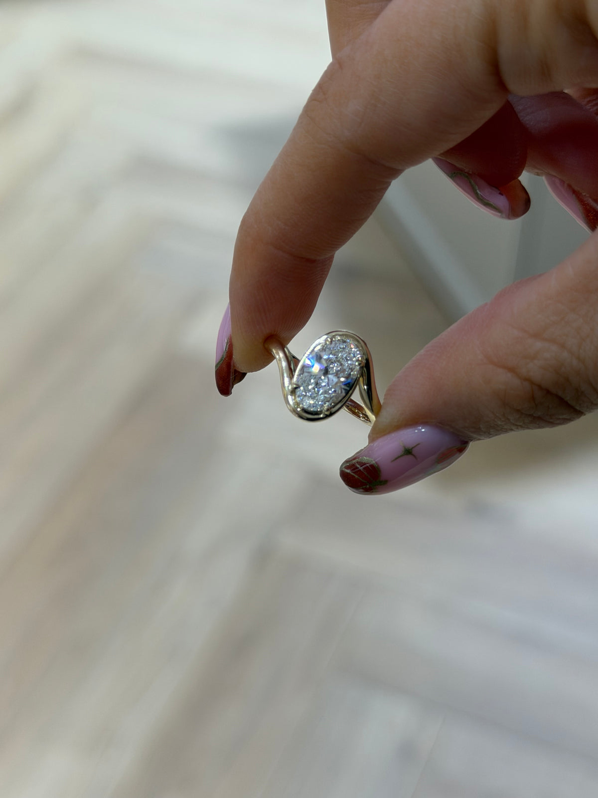 The Embrace bezel set oval lab diamond solitaire with sweeping 9k yellow gold band