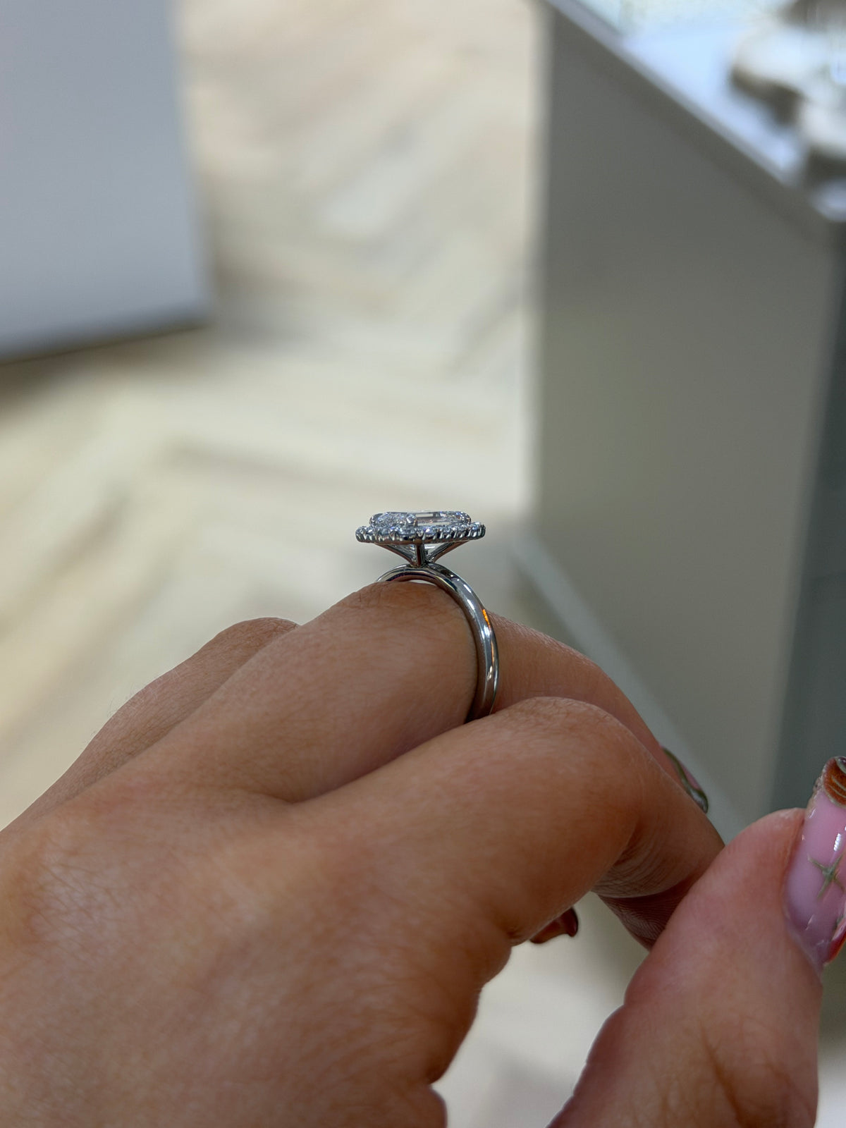 The Opulence emerald cut diamond halo engagement ring on a slim platinum band