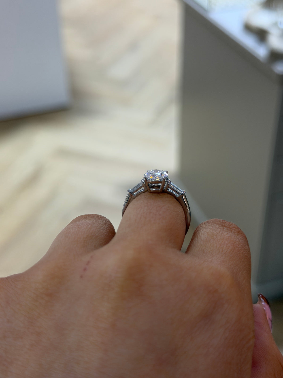 The Florence 2.30ct oval lab diamond three stone ring in platinum, side view on the hand
