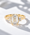 The Margot, 2ct emerald cut lab grown diamond three stone engagement ring in 9k yellow gold