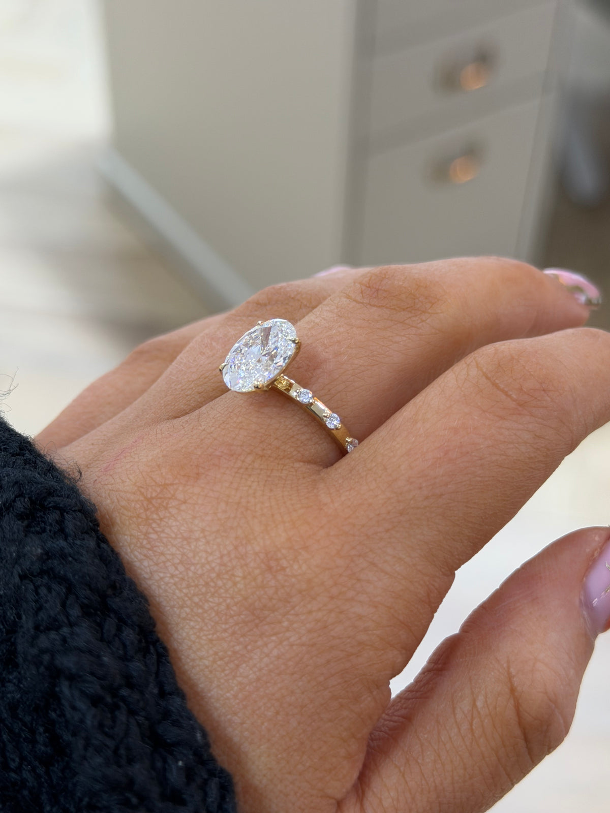 The Lumière oval lab diamond ring with accent stones along the 9k yellow gold band, side view