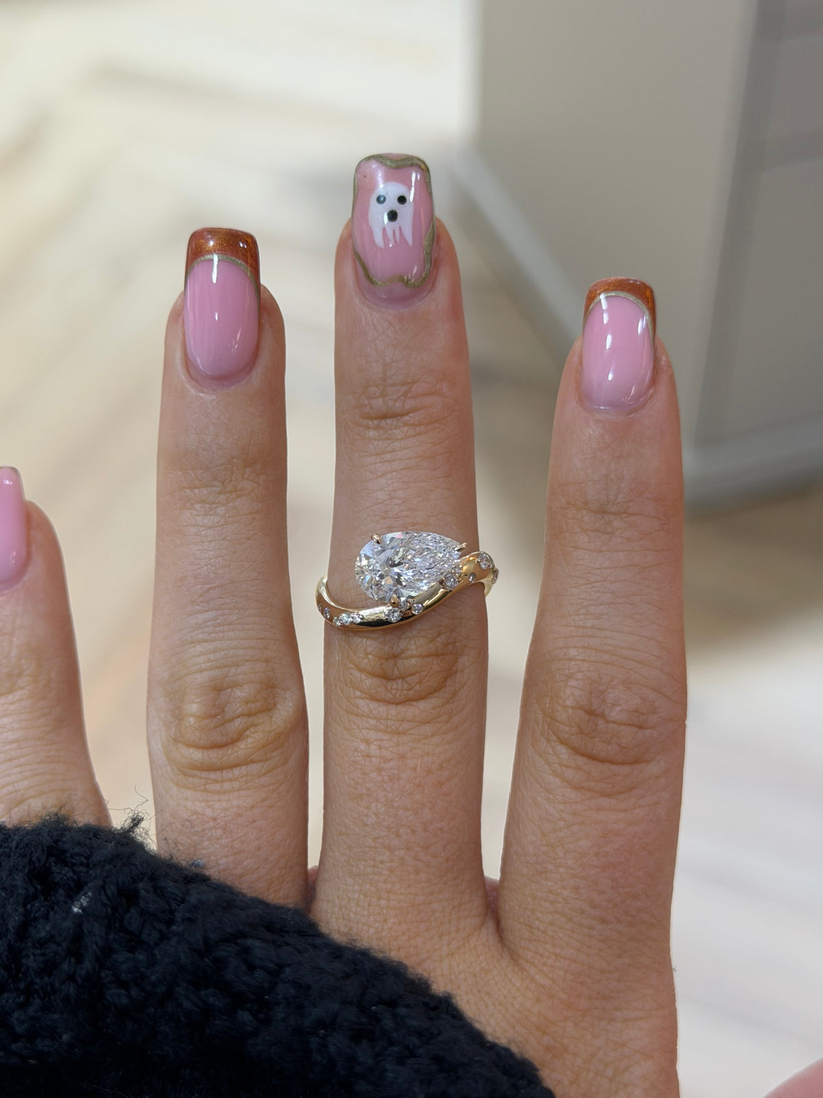 The Orbit pear lab diamond engagement ring with sculptural band, worn on the hand