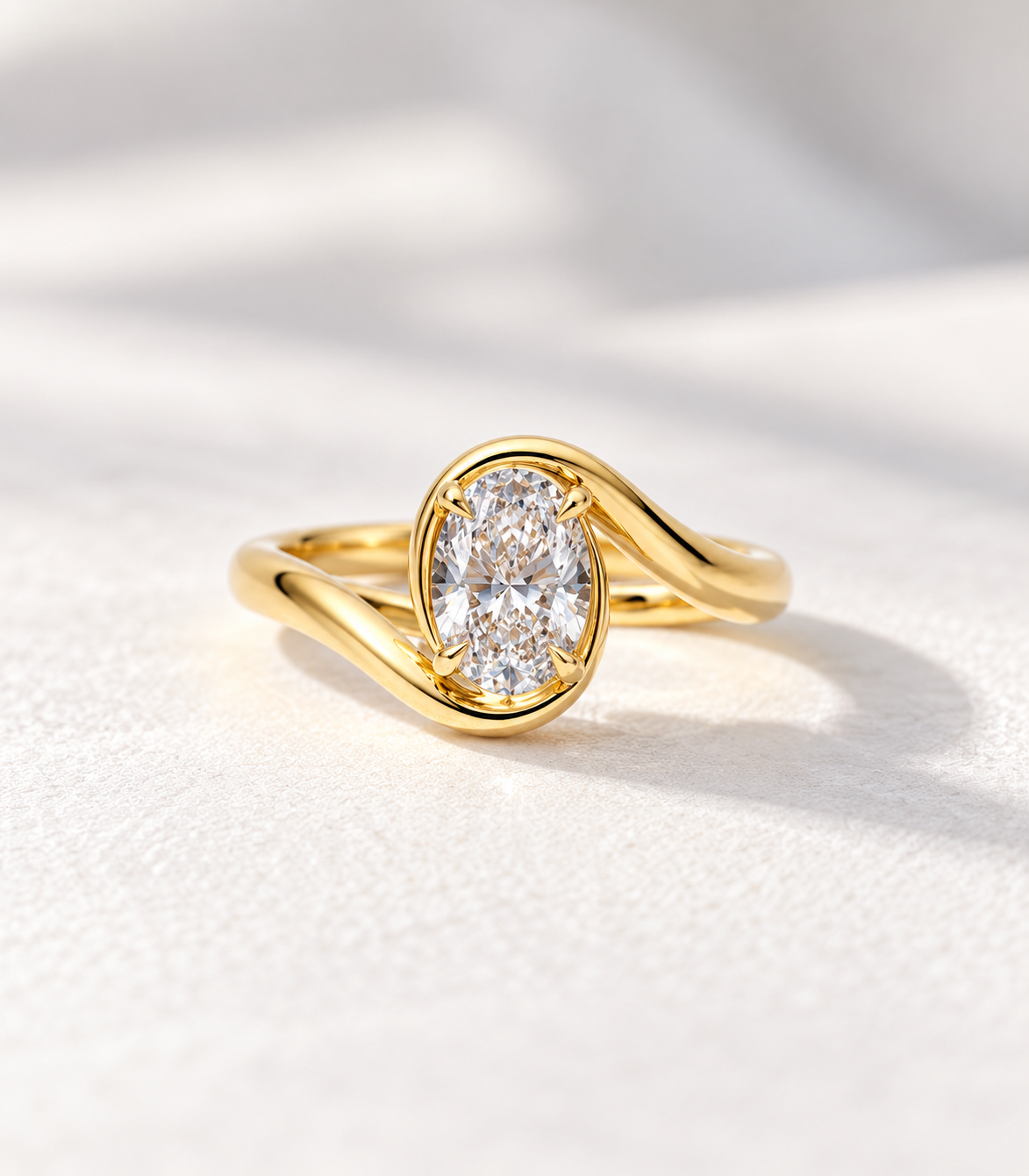 The Embrace, 2ct oval lab grown diamond bezel set engagement ring with bypass band in 9k yellow gold