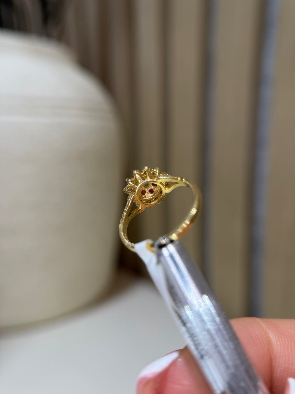 Beneath of the ruby, diamond and gold cluster ring. 