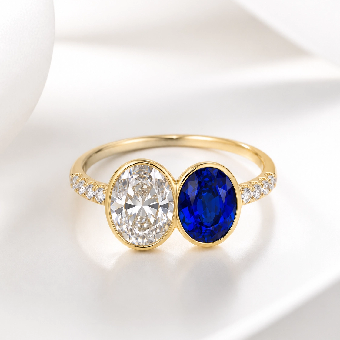 The Midnight Ring, oval lab diamond and blue lab sapphire bezel set toi et moi ring in 9k yellow gold